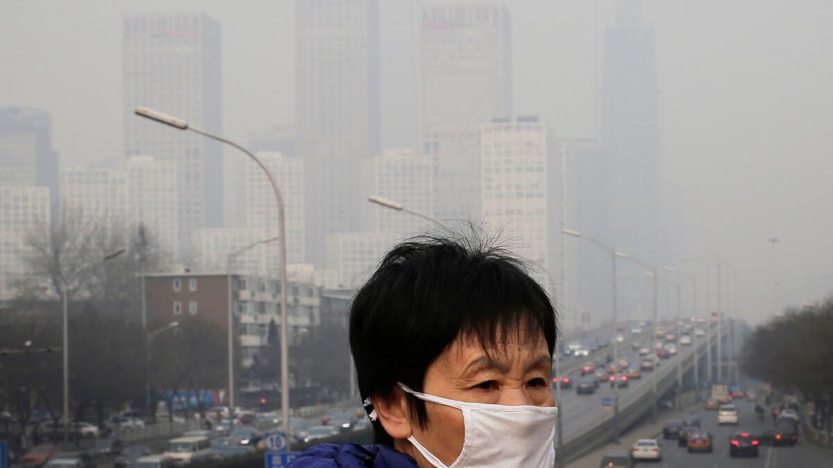 A woman wears a mask for protection against air pollution in Beijing. (Andy Wong / Associated Press)