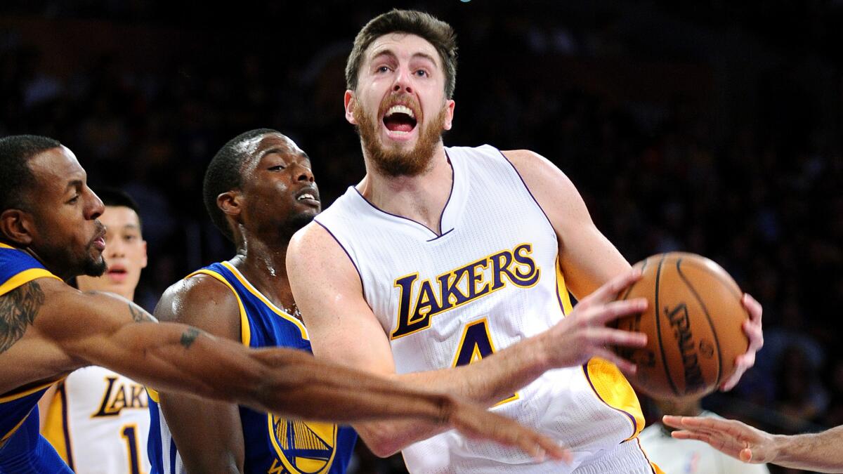 Lakers forward Ryan Kelly, right, is fouled by Warriors guard Andre Iguodala while driving to the basket during the Lakers' 136-115 loss Sunday at Staples Center.