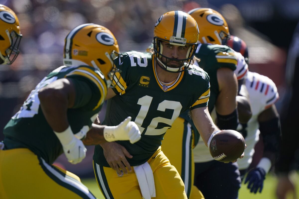 Green Bay Packers quarterback Aaron Rodgers (12) hands the ball off to running back A.J. Dillon during the first half of an NFL football game Sunday, Oct. 17, 2021, in Chicago. (AP Photo/Nam Y. Huh)