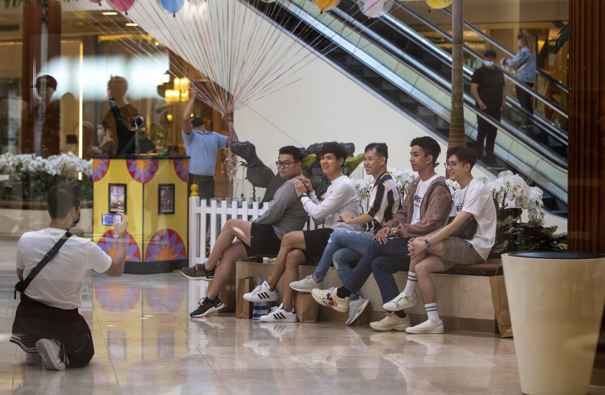 Shoppers line up on a bench for a group photo.