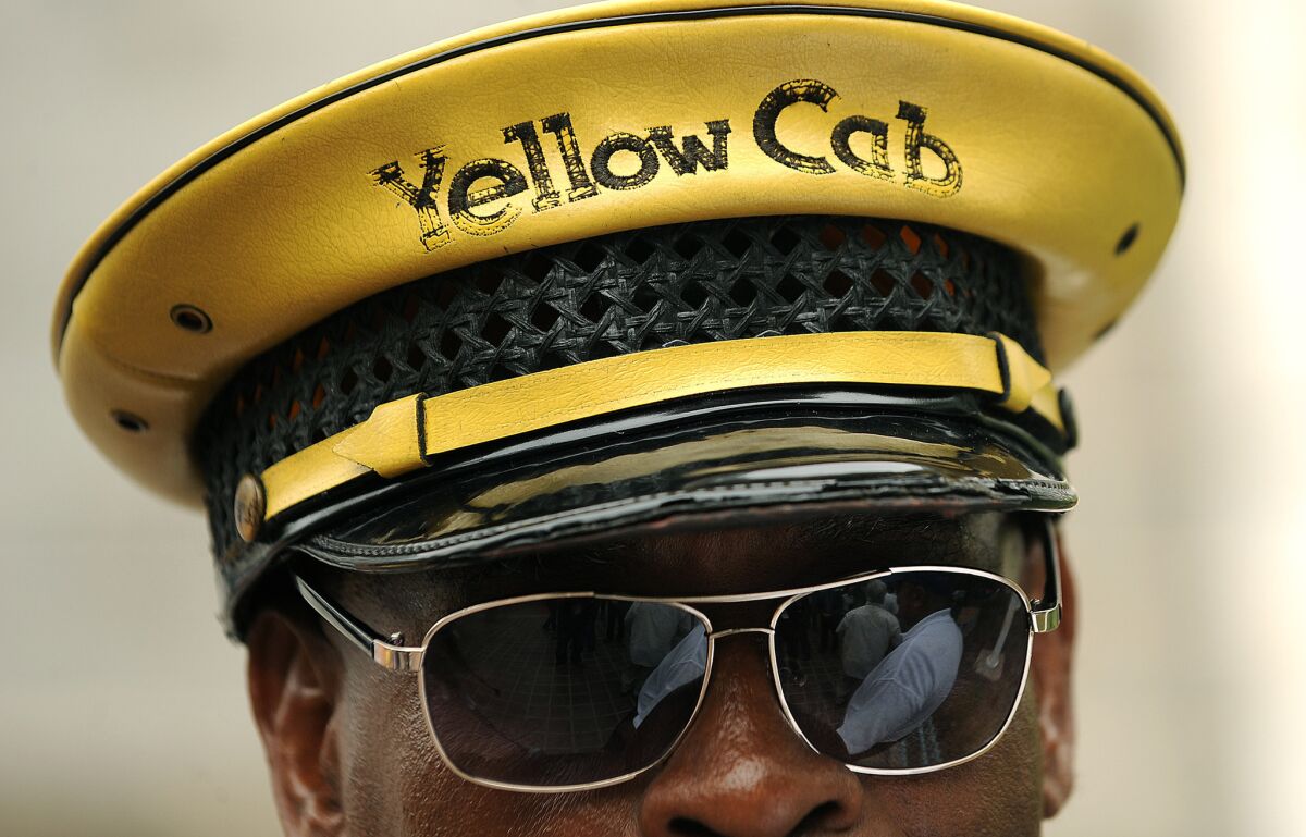 Yellow Cab employee D'Mitch Davis stands outside City Hall during a June protest against ride-share apps that cab drivers said were hurting their business.