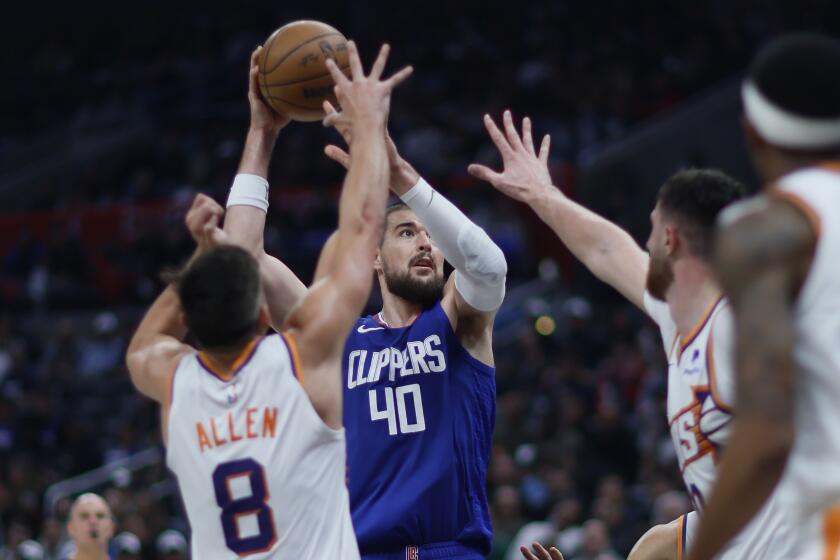 Los Angeles, CA - January 08: Clippers center Ivica Zubac, #40, center goes up for a shot against Phoenix Suns guard Grayson Allen, #8, left, center Jusuf Nurkic, # 20, second from right, and center Bol Bol, #11, right, in the second half at Crypto.com Arena in Los Angeles Monday, Jan. 8, 2024. (Allen J. Schaben / Los Angeles Times)