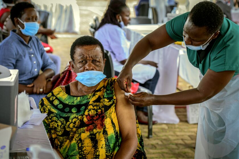A woman receives a coronavirus vaccination at the Kololo airstrip in Kampala, Uganda, Monday, May 31, 2021. Africa is especially vulnerable. As virus cases surge in the world's poorest countries, a sense of dread is growing among millions of the unvaccinated, especially those who toil in the informal, off-the-books economy, live hand-to-mouth and pay cash in health emergencies. (AP Photo/Nicholas Bamulanzeki)