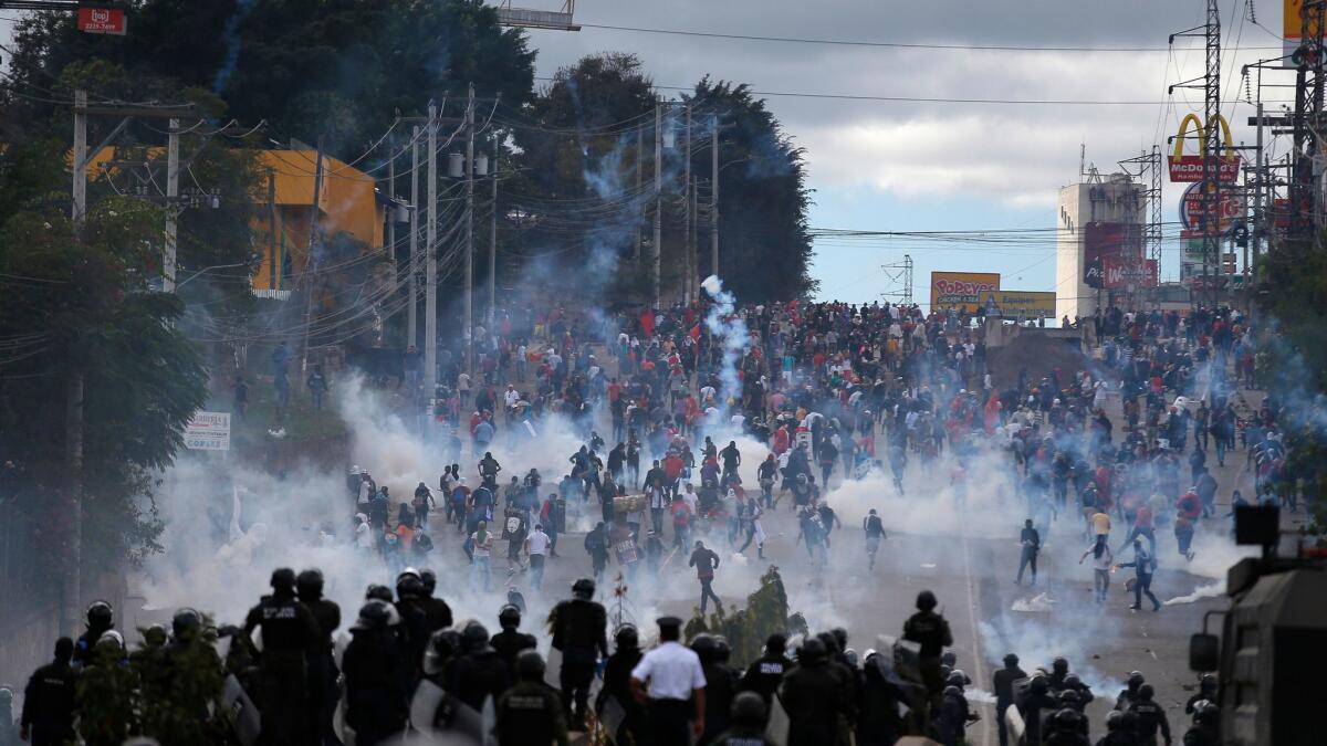 Soldiers and police launch tear gas at demonstrators marching to protest the inauguration of President Juan Orlando Hernandez in Tegucigalpa, Honduras.