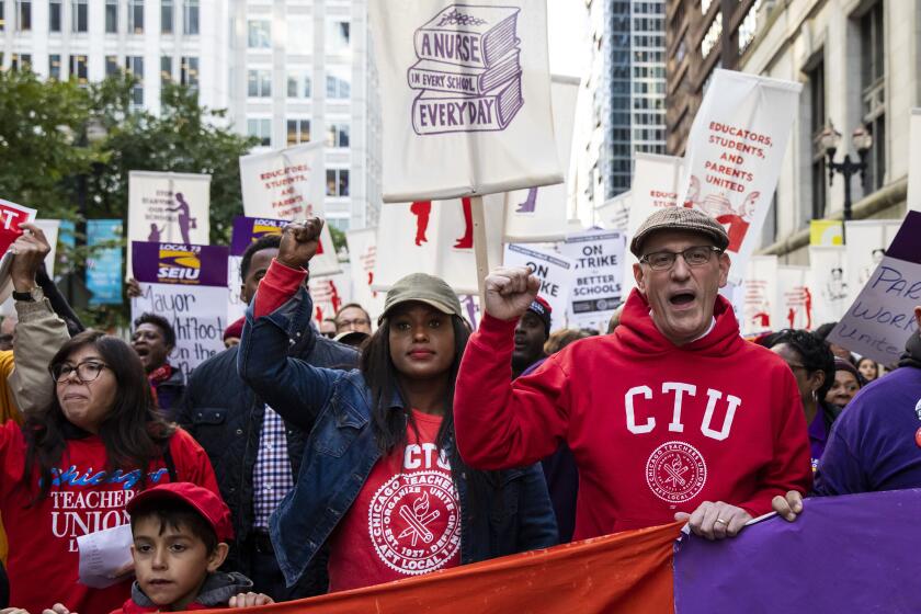 In this Oct. 14, 2019 photo, Chicago Teachers Union President Jesse Sharkey, center right, and Vice President Stacy Davis Gates, center, left, march with members of the CTU and SEIU Local 73 through the Loop after a rally, three days before the unions could walk off the job on strike. Chicago's public schools have canceled classes after the teachers' union president announced that his bargaining team will recommend teachers vote to go on strike. Mayor Lori Lightfoot said Wednesday, Oct. 16, 2019, that classes would be canceled Thursday after determining that she can't accept the Chicago Teachers Union's demands, which she says would cost the city $2.5 billion it can't afford. (Ashlee Rezin Garcia/Chicago Sun-Times via AP)