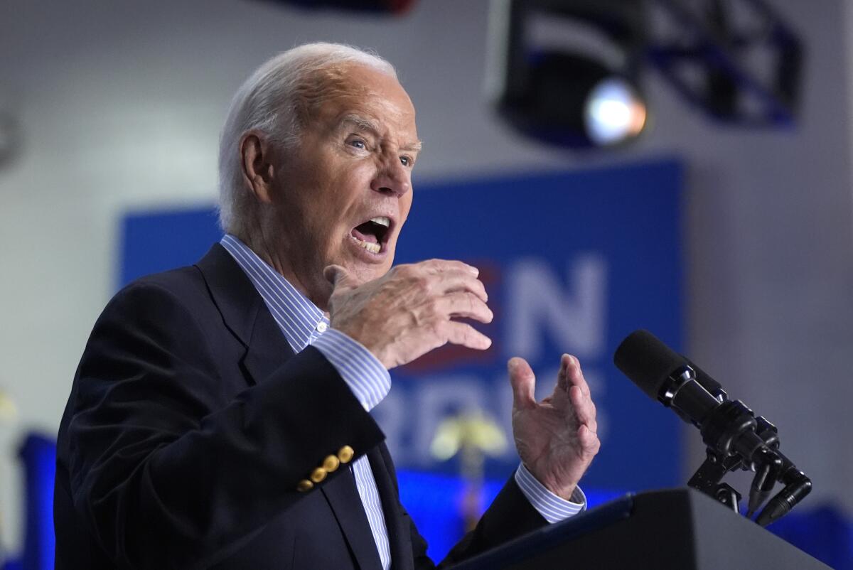 President Biden gestures with his hands as he speaks at a campaign rally.