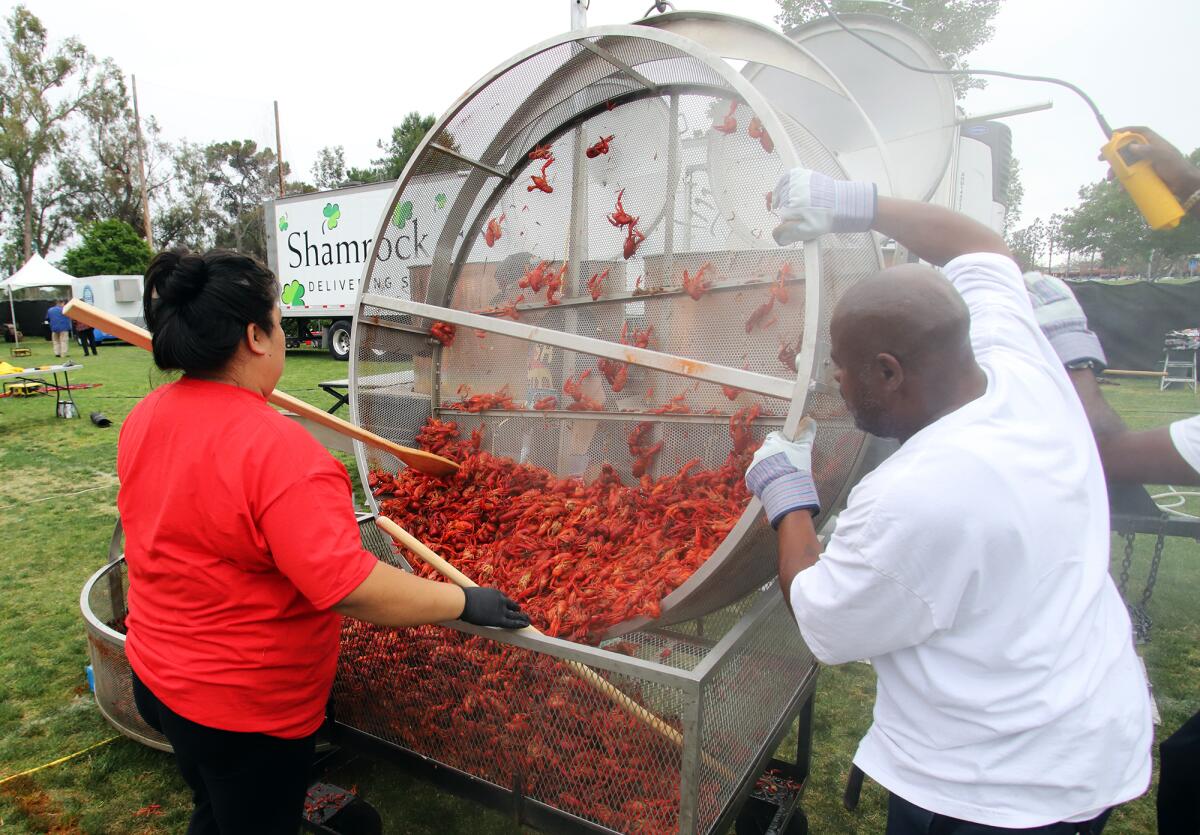 Lilly Dao scoops fresh Louisiana crawfish out of the crawfish boil at Fountain Valley Sports Park on Friday.