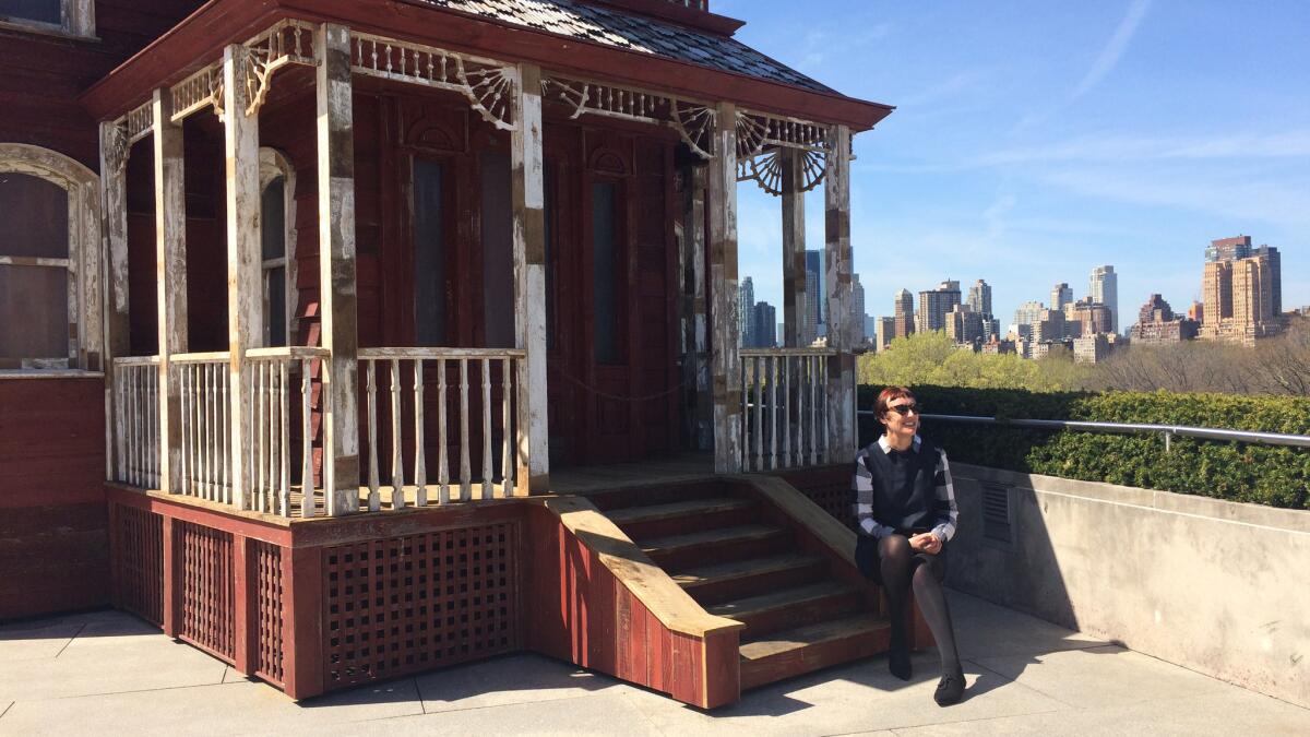 Artist Cornelia Parker sits on her sculpture, "Transitional Object (PsychoBarn)" on the roof of the Met.