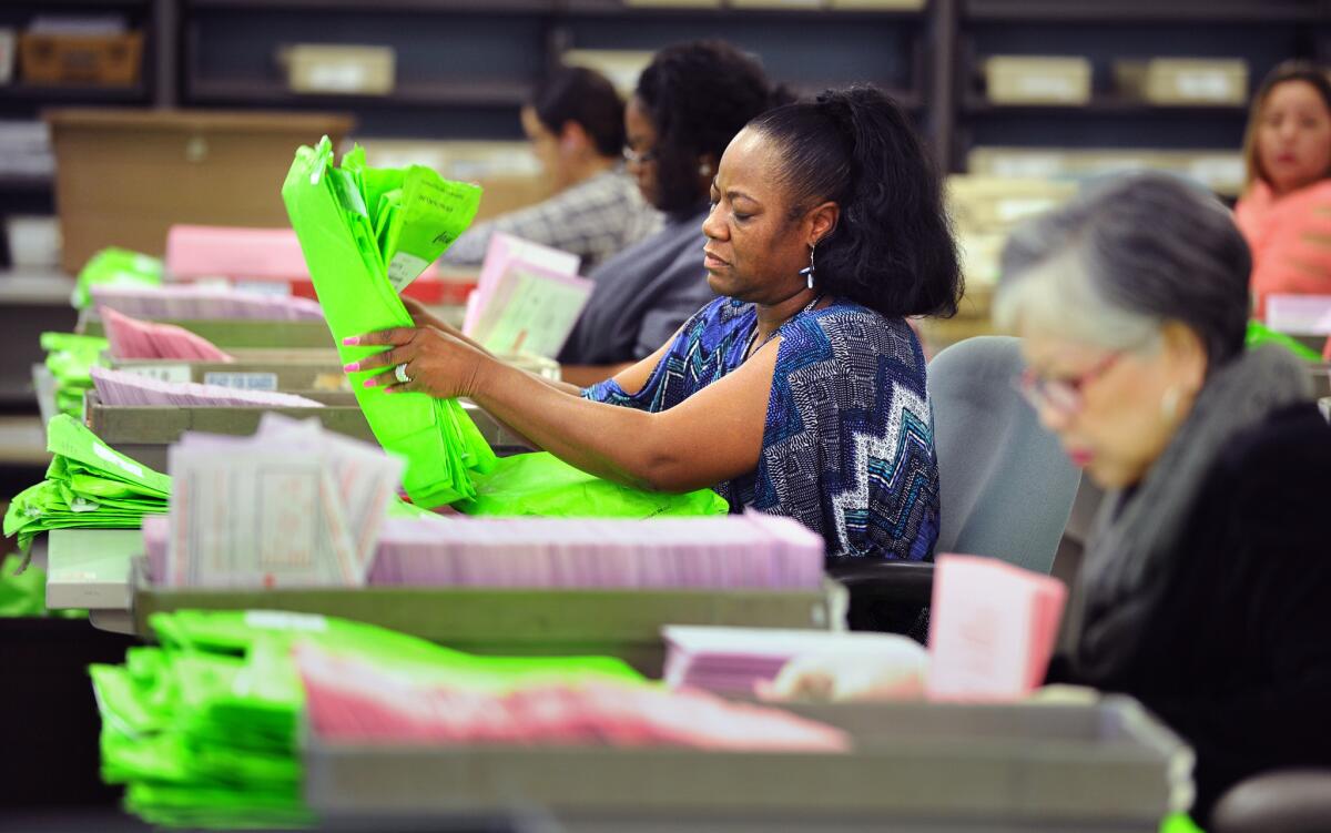 Workers count mail-in and absentee ballots at the L.A. County Registrar-Recorder County Clerk office in Norwalk during the November 2014 election.
