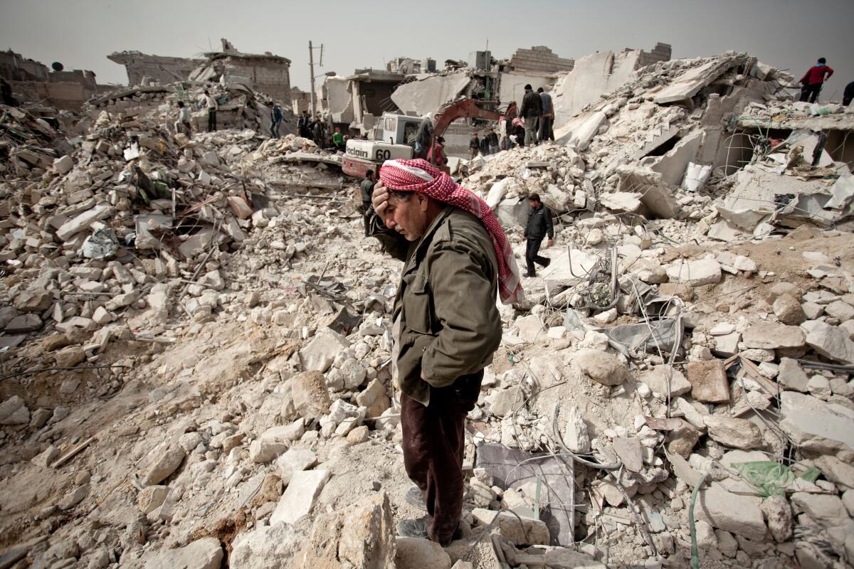 A man stands amid the rubble of his house in Aleppo, Syria.  