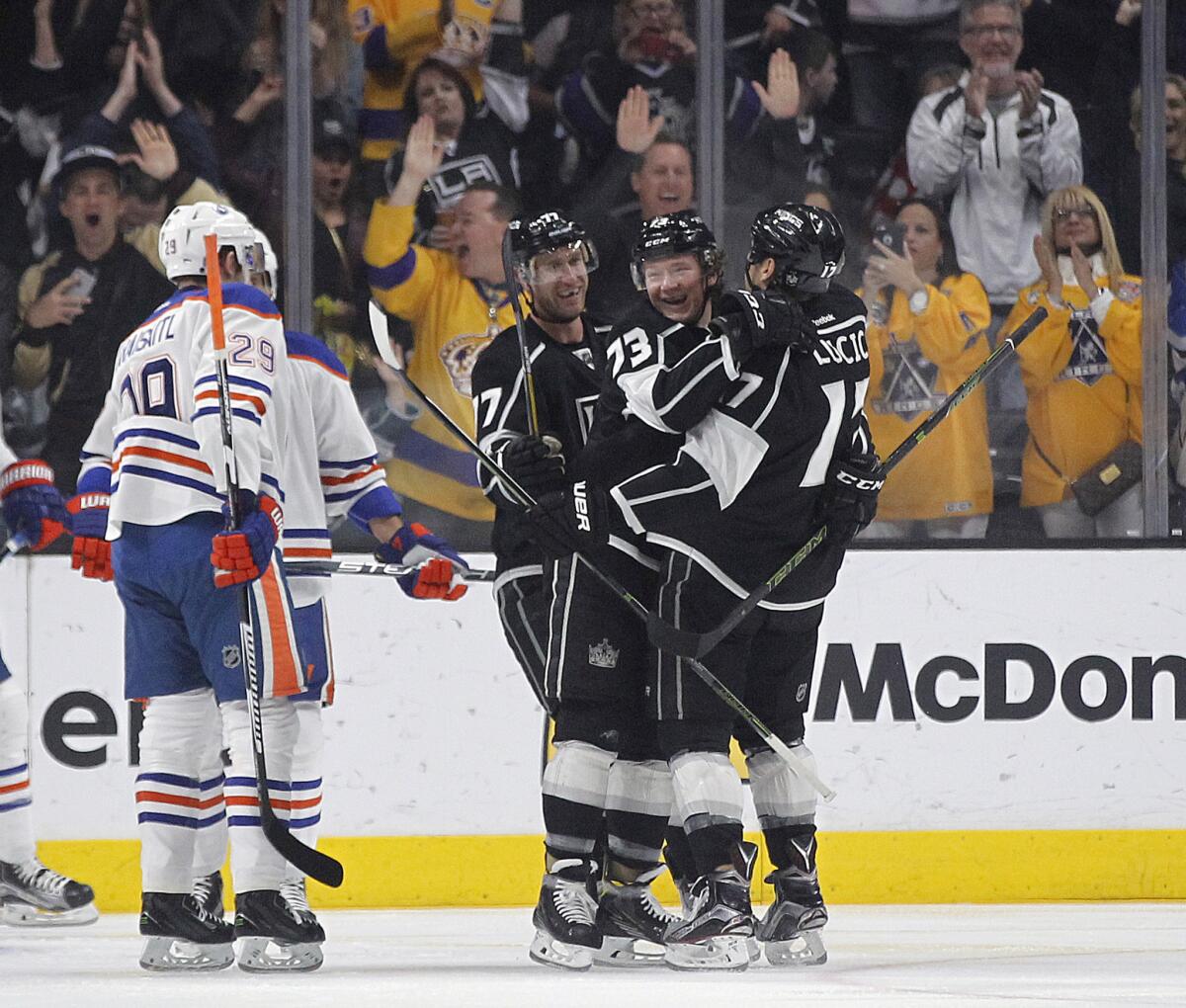 Kings center Tyler Toffoli (73) celebrates his goal with left wing Milan Lucic, right, and center Jeff Carter (77) as Oilers center Leon Draisaitl (29) skates by during the first period.