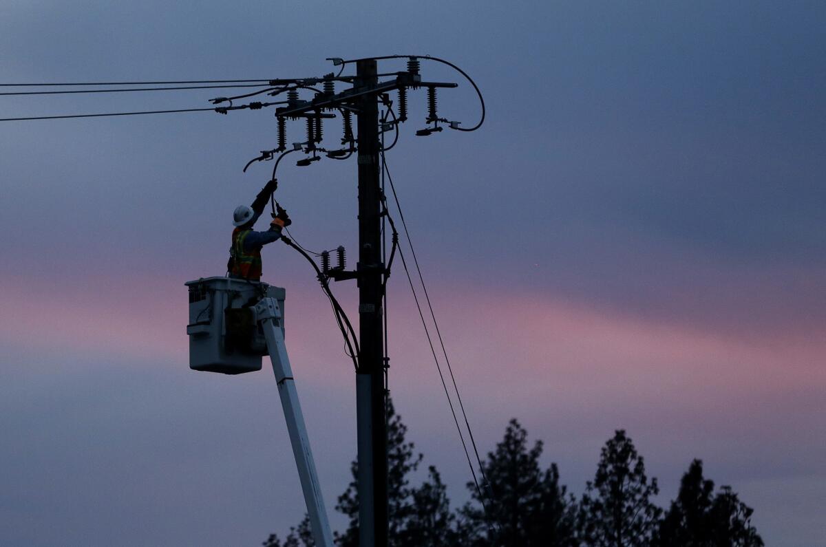 A Pacific Gas & Electric lineman works to repair a power line on Nov. 26, 2018, in Paradise, Calif. PG&E may shut off power to some counties in Northern California in advance of critical fire weather.