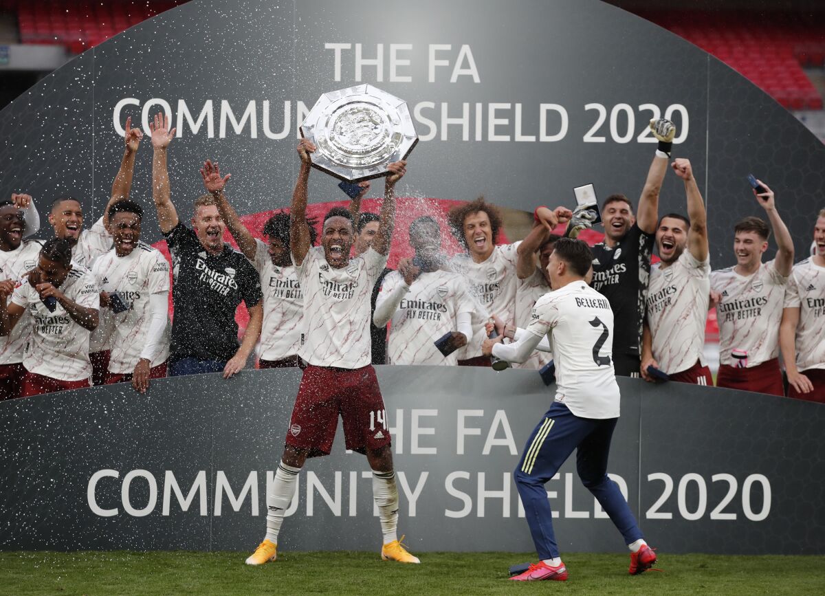 Arsenal's Pierre-Emerick Aubameyang lifts the trophy after winning the English FA Community Shield soccer match between Arsenal and Liverpool at Wembley stadium in London, Saturday, Aug. 29, 2020. (Andrew Couldridge/Pool via AP)