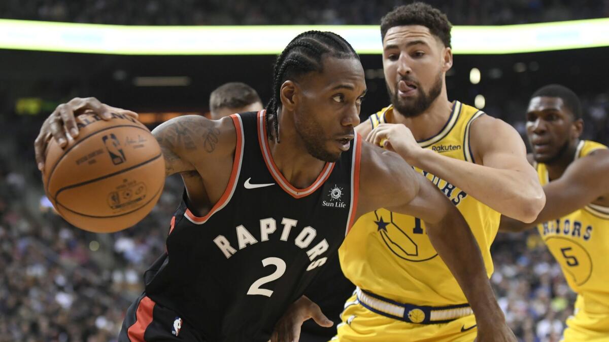 Toronto Raptors forward Kawhi Leonard (2) drives past Golden State Warriors guard Klay Thompson (11) during the first half.