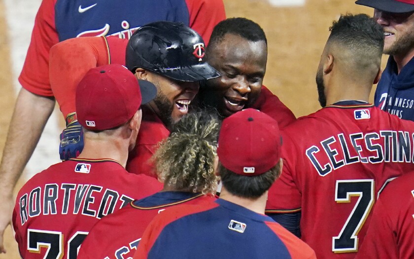 Minnesota Twins' Miguel Sano, center hugs Nelson Cruz after Cruz's two-run home run off New York Yankees relief pitcher Aroldis Chapman during the ninth inning of a baseball game Thursday, June 10, 2021, in Minneapolis. The Twins won 7-5. (AP Photo/Jim Mone)