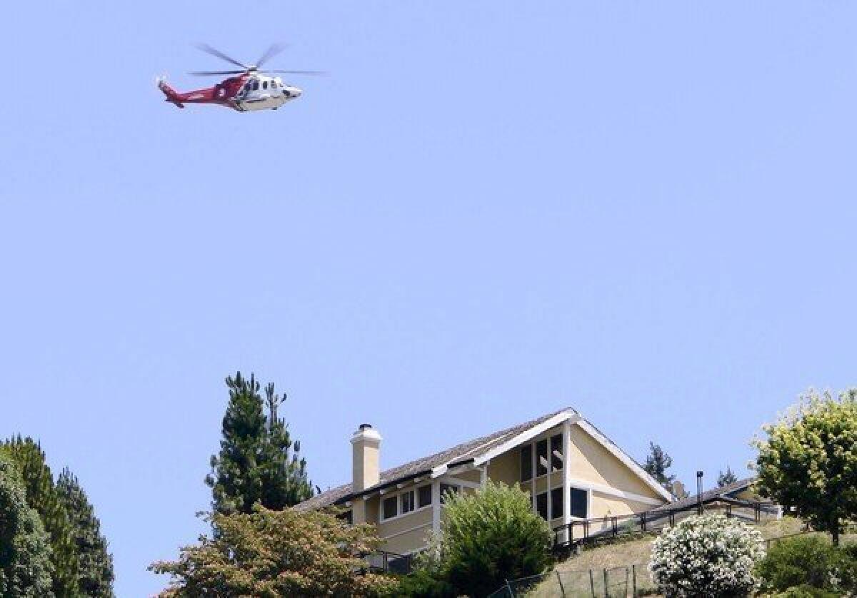 A helicopter flies above a house in the L.A. region.