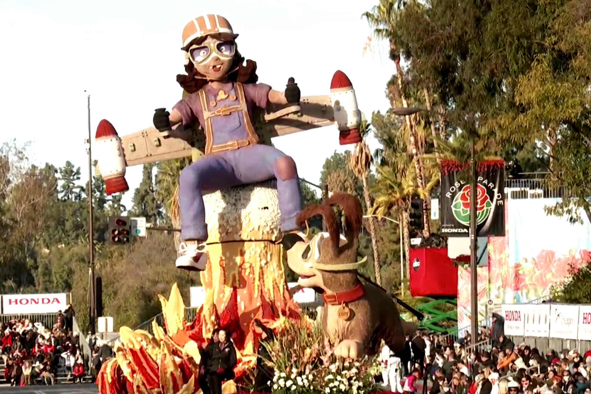 America Honda float shows a girl trying to achieve liftoff with a homemade rocket on her back