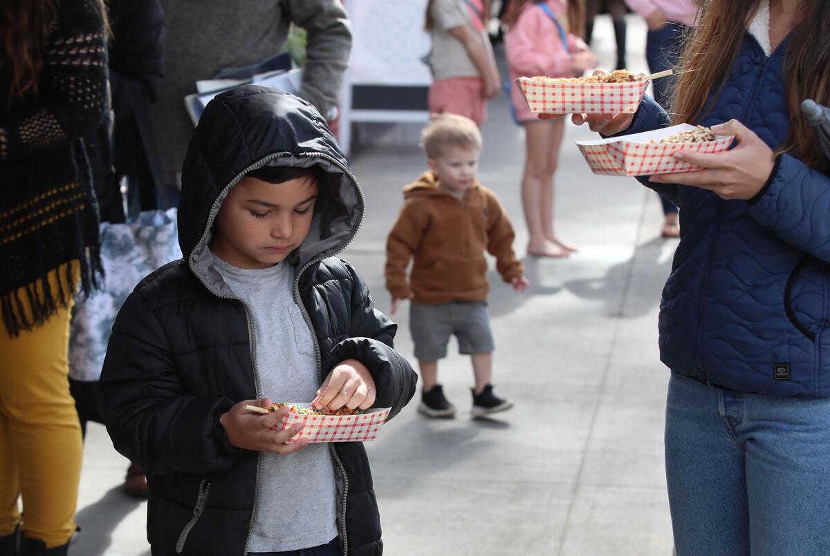 Kids gather around for frozen bananas at the Sugar 'n Spice frozen banana stand.