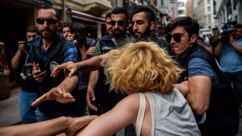 Riot police officers detain an LGBT demonstrator during a rally staged by the LGBT community on Istiklal avenue in Istanbul on June 26, 2016.