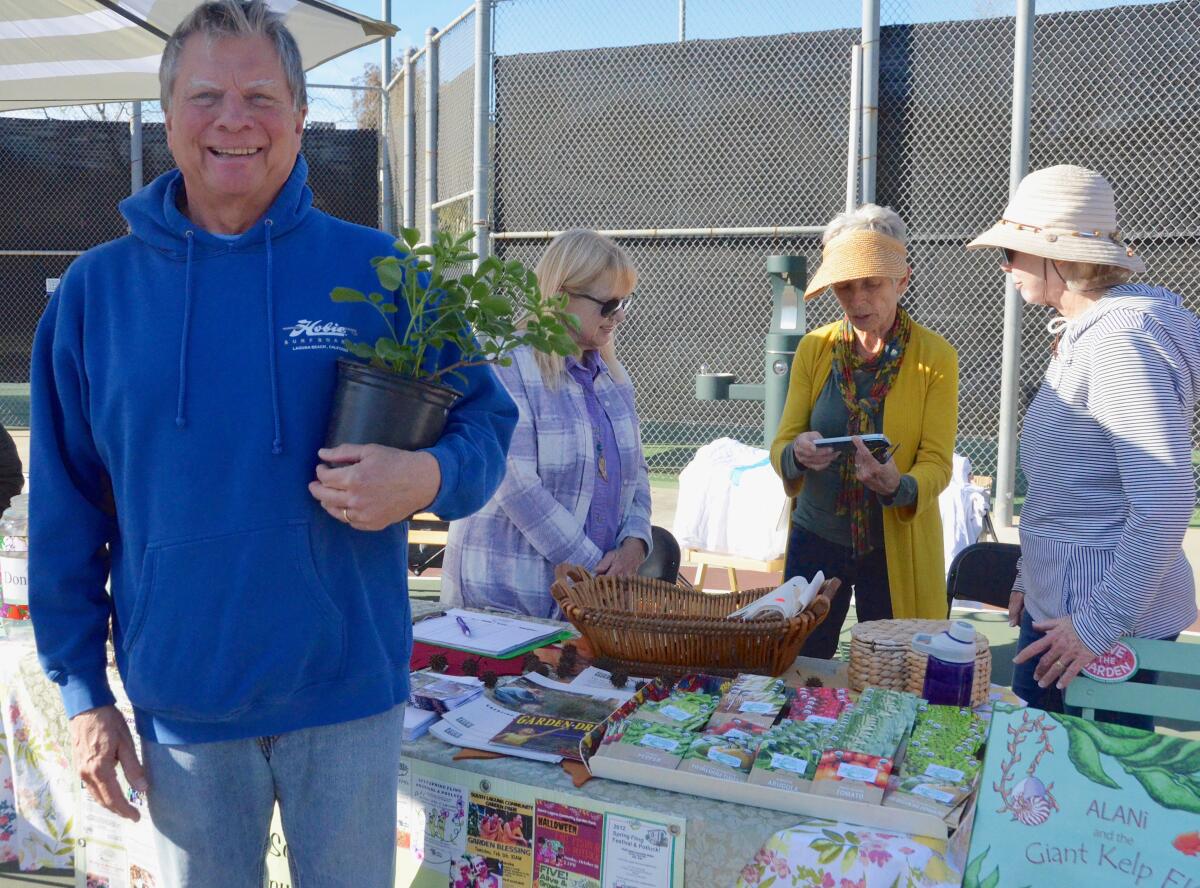 Jim Van Dalfsen picks out an elderberry plant from South Laguna Community Garden Park's table.