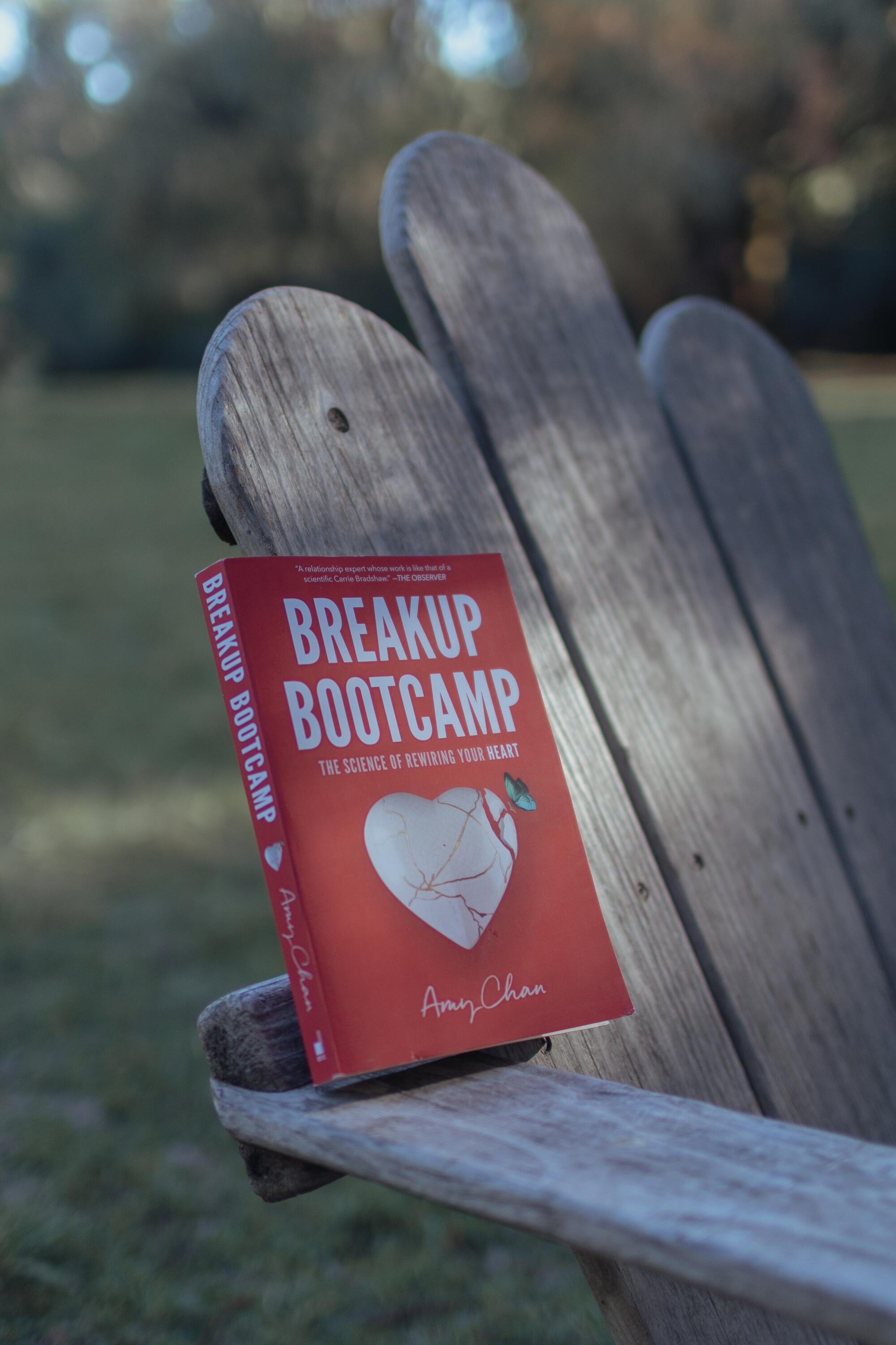 The book "Breakup Bootcamp" on an Adirondack chair.