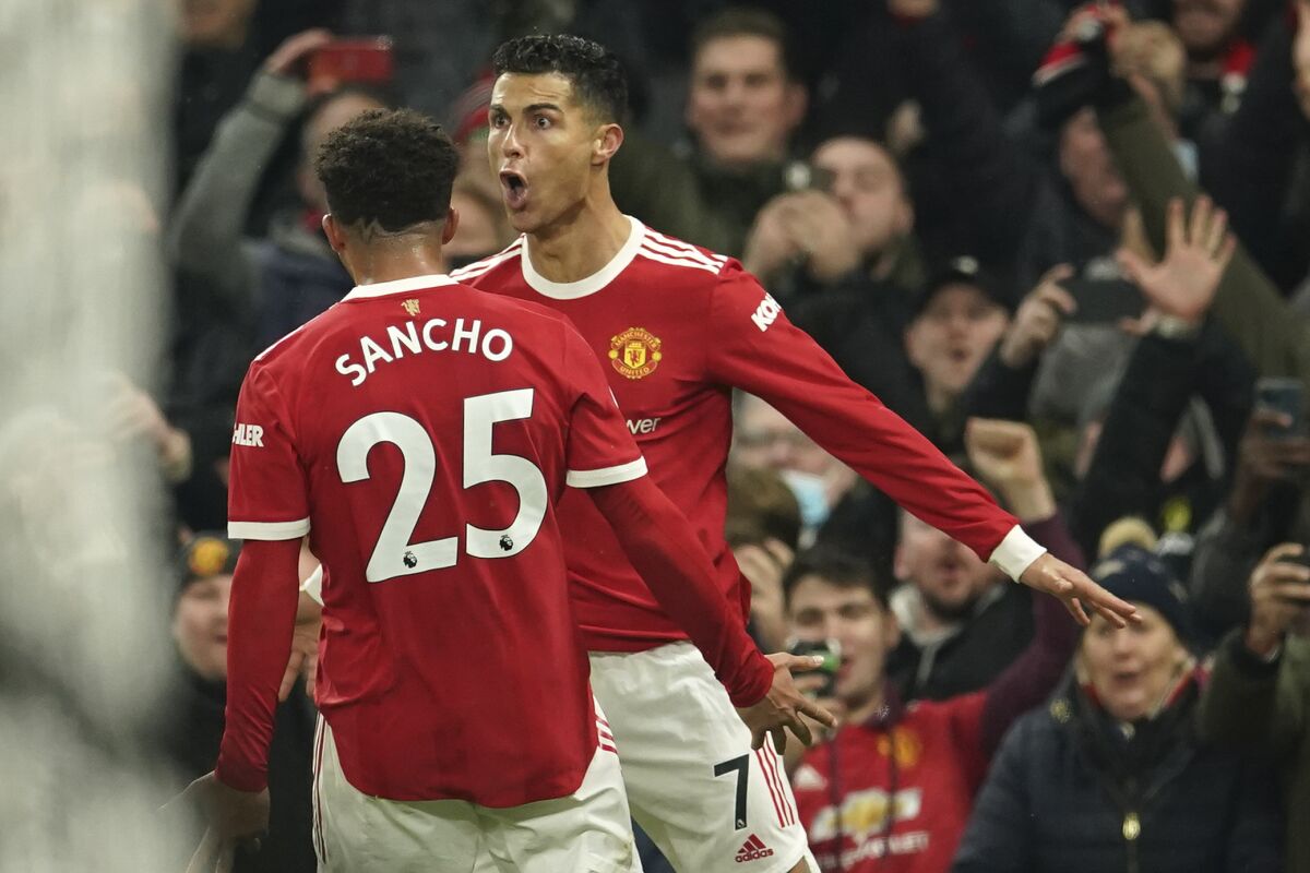Manchester United's Cristiano Ronaldo, right, celebrates with Manchester United's Jadon Sancho after scoring his side's third goal during the English Premier League soccer match between Manchester United and Arsenal at Old Trafford stadium in Manchester, England, Thursday, Dec. 2, 2021. (AP Photo/Dave Thompson)