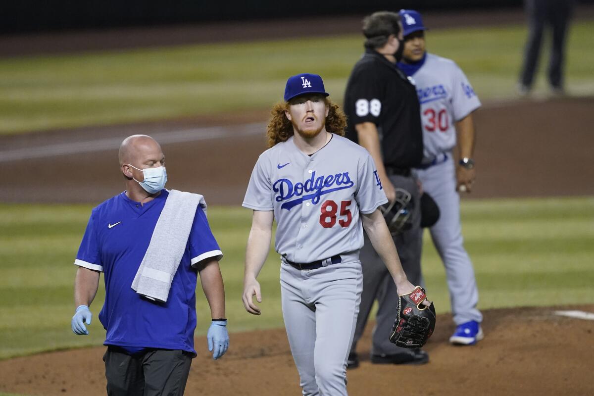 Dodgers starting pitcher Dustin May leaves the game after taking a hit off his foot.