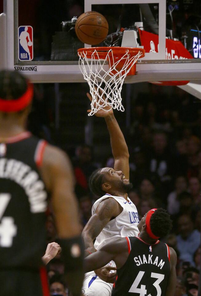 Clippers forward Kawhi Leonard slices to the basket for a layup against the Raptors during the third quarter of a game Nov. 11 at Staples Center.