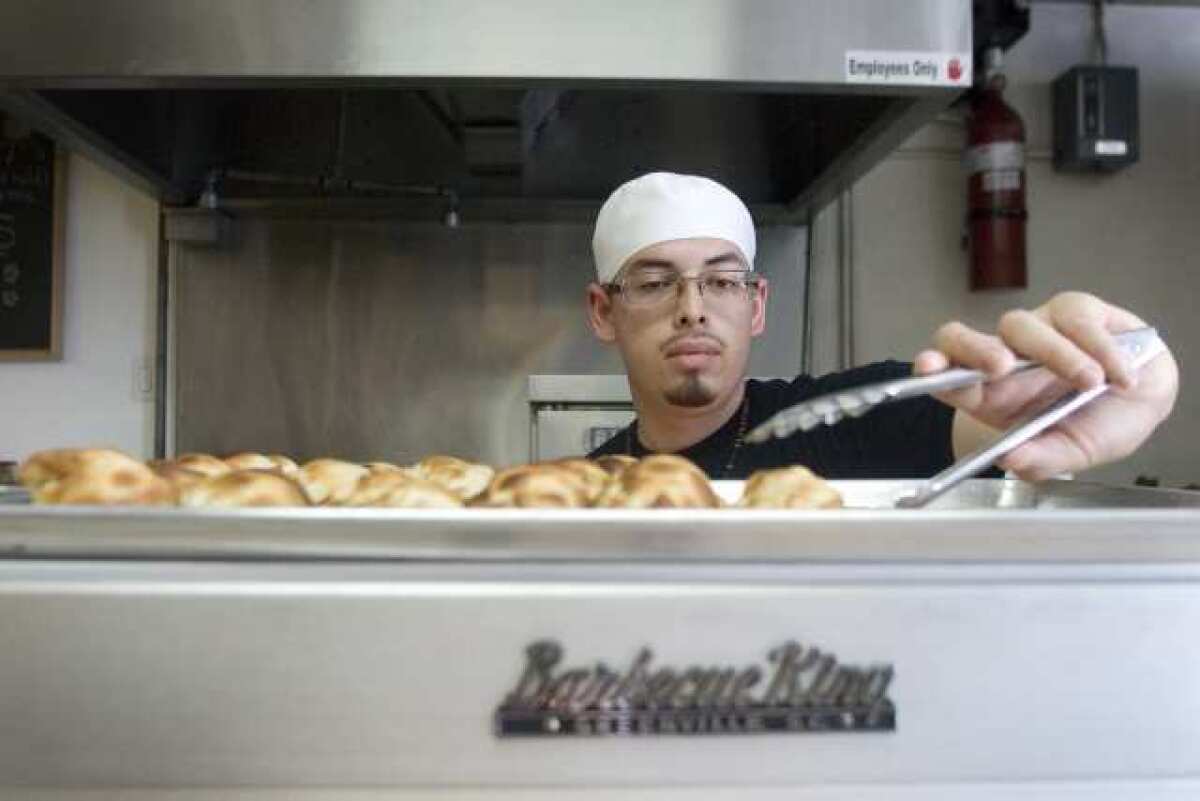 Chef Brian Coronel stocks up some empanadas in a warm oven at World Empanadas in Burbank.