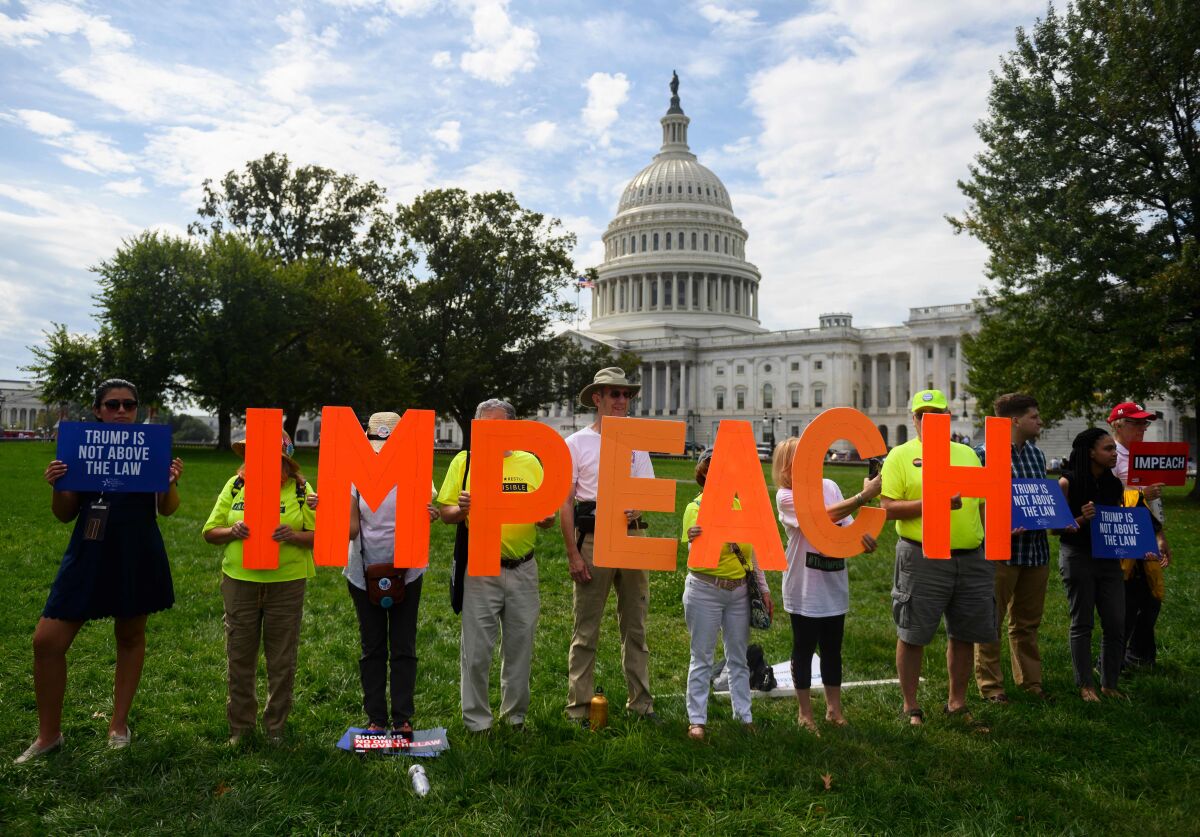 Protesters hold up letters reading "impeach" in front of the U.S. Capitol building in 2019. 