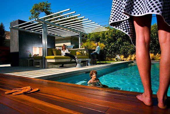 Independent film and TV producer Gail Katz (on the sofa) and her husband, attorney Bruce Wessel, called on architect David Hertz to transform their Santa Monica backyard into a comfortable, appealing outdoor room, framed by an open-air pavilion, with a view of the pool. Their kids Nora (19, in foreground) and Jacob (16) use the backyard year-round.--Barbara Thornburg PAVILION Dimensions: 12 feet by 12 feet Materials: Integral-colored, steel-troweled stucco with 2-inch-by-2-inch clear anodized aluminum; Perennials "Very Terry" outdoor fabric at David Sutherland Showroom Cost: About $150,000 Architect: David Hertz, Santa Monica Interior design: Hermosillo & Ross, Los Angeles