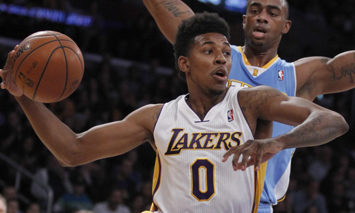 Lakers small forward Nick Young drives inside on Denver Nuggets forward Darrell Arthur during a game on Jan. 5.