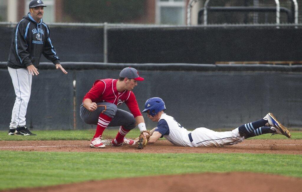 Corona del Mar's Alex Shadid beats the tag of Woodbridge's Spencer Weston at third base, while Coach John Emme looks on.