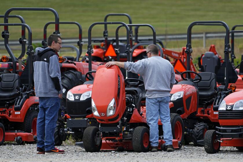 Men look at Kubota tractors at a dealer in Uniontown, Pa., on Friday, June 9, 2023. On Wednesday, the Labor Department reports on U.S. consumer prices for June. (AP Photo/Gene J. Puskar)