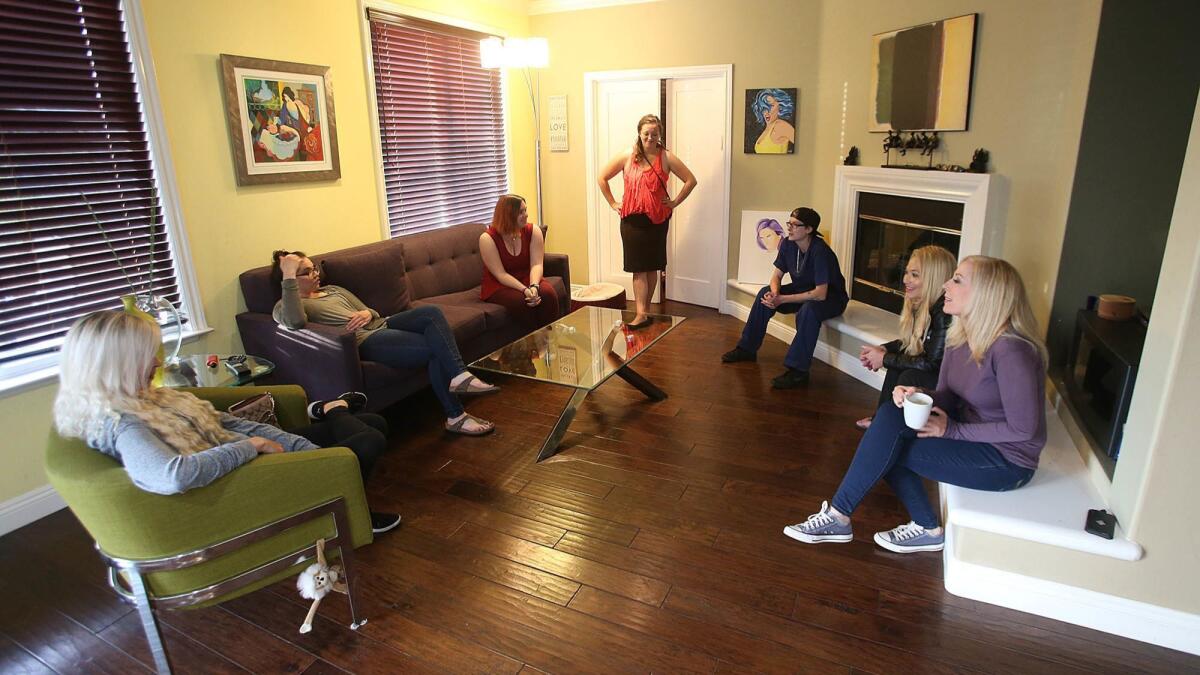 Lauri Burns, far right, chats with former foster kids in the living room of her house in. Burns' Teen Project provides a transitional home for girls who've aged out of the foster-care system at 18.