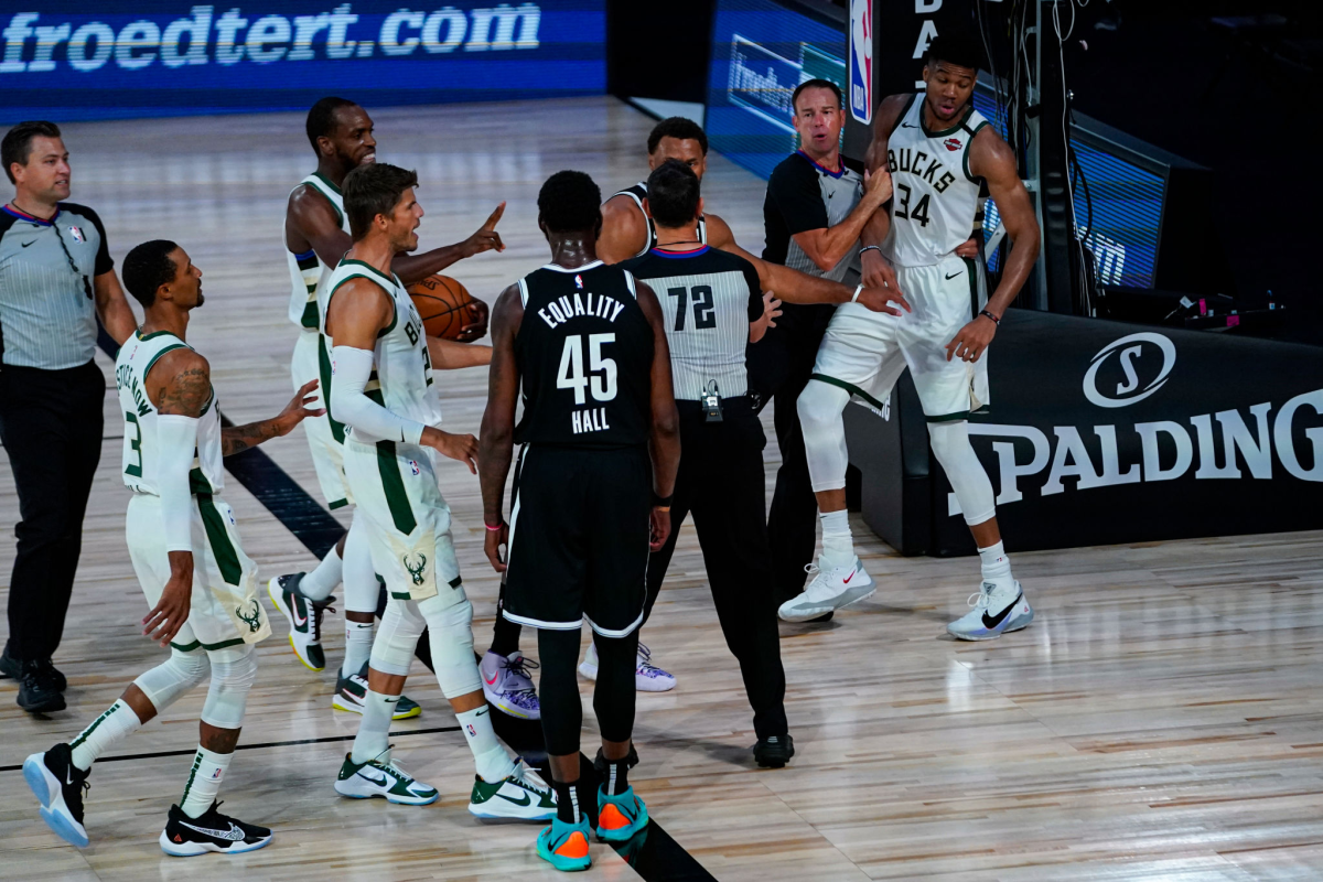 Referees separate players from the Milwaukee Bucks and Brooklyn Nets after a scuffle.