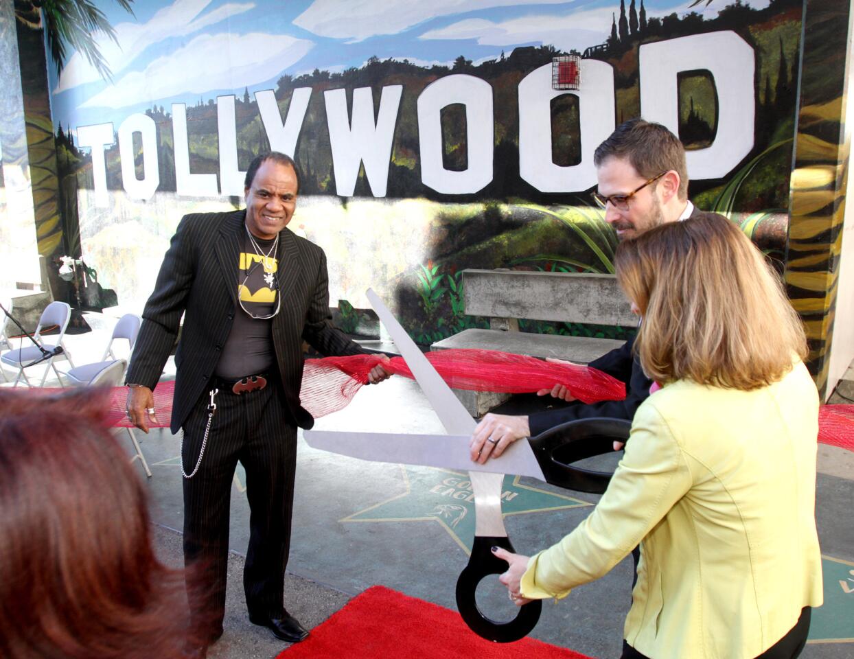 Artist Randall Williams, left, school principal Dr. Thomas Crowther, center, and Foundation president Chey Widdop, right, cut the ribbon at the Toll Middle School at the Hooray for Tollywood official mural unveiling event at the Glendale school on Tuesday, January 12, 2016. The Toll Foundation and the Titan's ASB funded the project and artist Randall Williams created the mural.