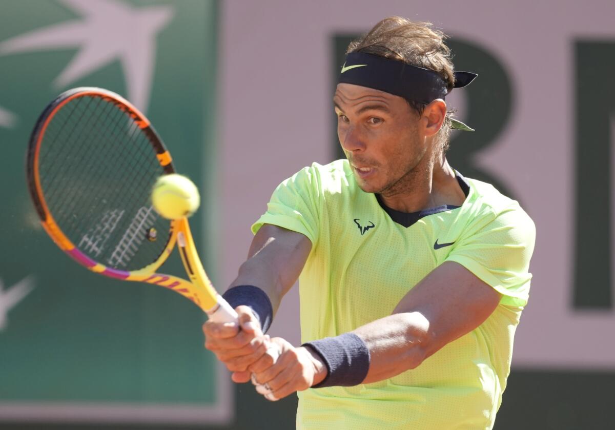 Rafael Nadal plays a return to Alexei Popyrin.