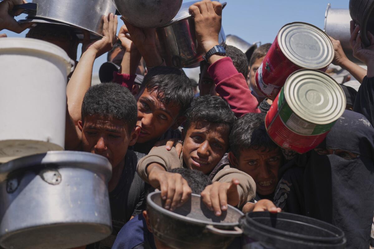 Palestinos tratan de obtener alimentos donados .
