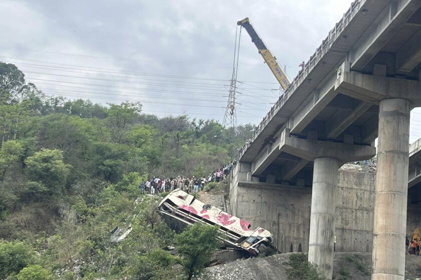 Rescuers prepare to use a crane after a bus carrying Hindu pilgrims to a shrine skid off a highway bridge into a Himalayan gorge near Jammu, India, Tuesday, May 30, 2023. (AP Photo/Channi Anand)