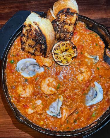 An overhead photo of a large skillet of red shrimp-and-oyster perloo from Joyce in downtown los angeles
