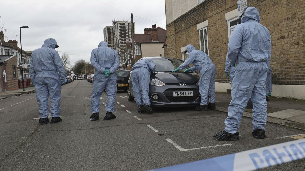 Forensic officers search the London scene Tuesday where a 17-year old girl was fatally shot Monday evening. Police in nearby Walthamstow found a boy shot and another stabbed.