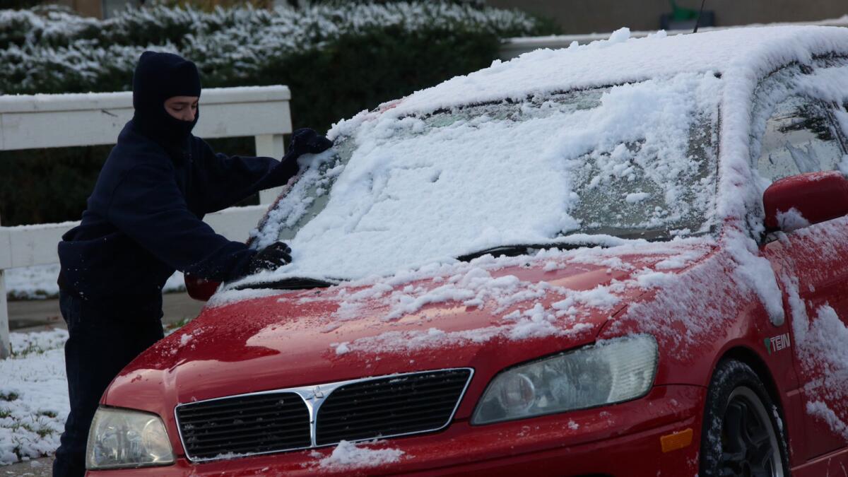 Bryant Forsythe, 11, clears snow off a car in Lake Elsinore amid the Dec. 31 Southern California deep freeze.