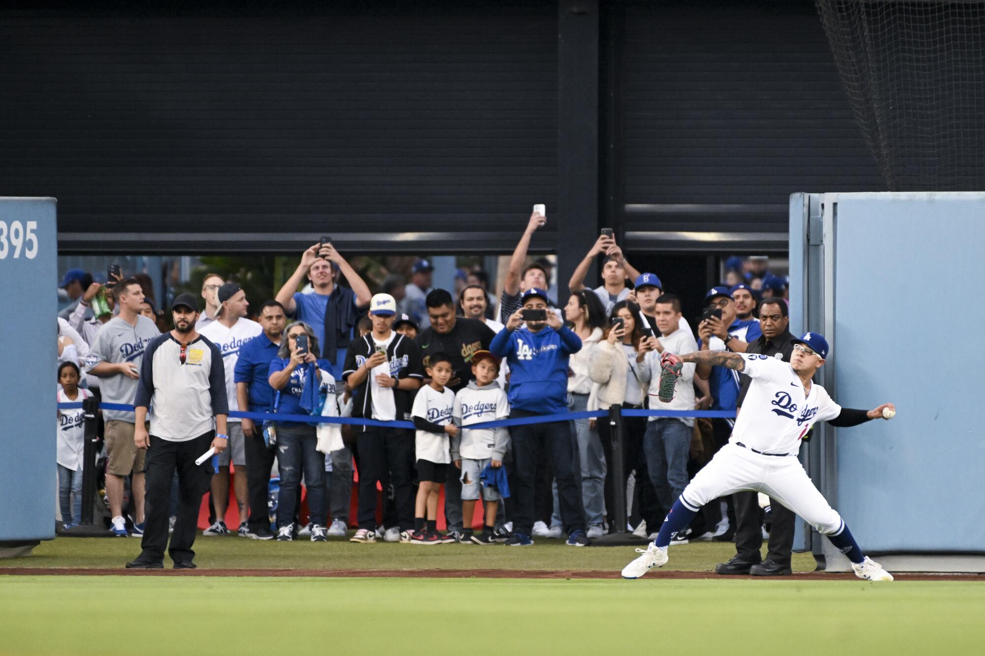 Dodgers starting pitcher Julio Urias warms up in front of fans.