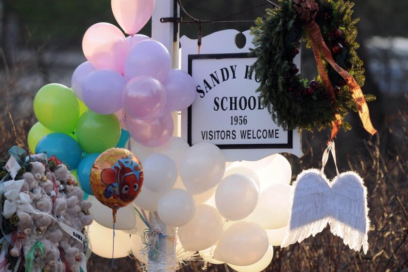 In this 2012 file photo, flowers, teddy bears, candles, balloons and a pair of angel wings left by mourners are seen at the Sandy Hook Elementary School sign. (Cloe Poisson /Hartford Courant/TNS) ** OUTS - ELSENT, FPG, TCN - OUTS **