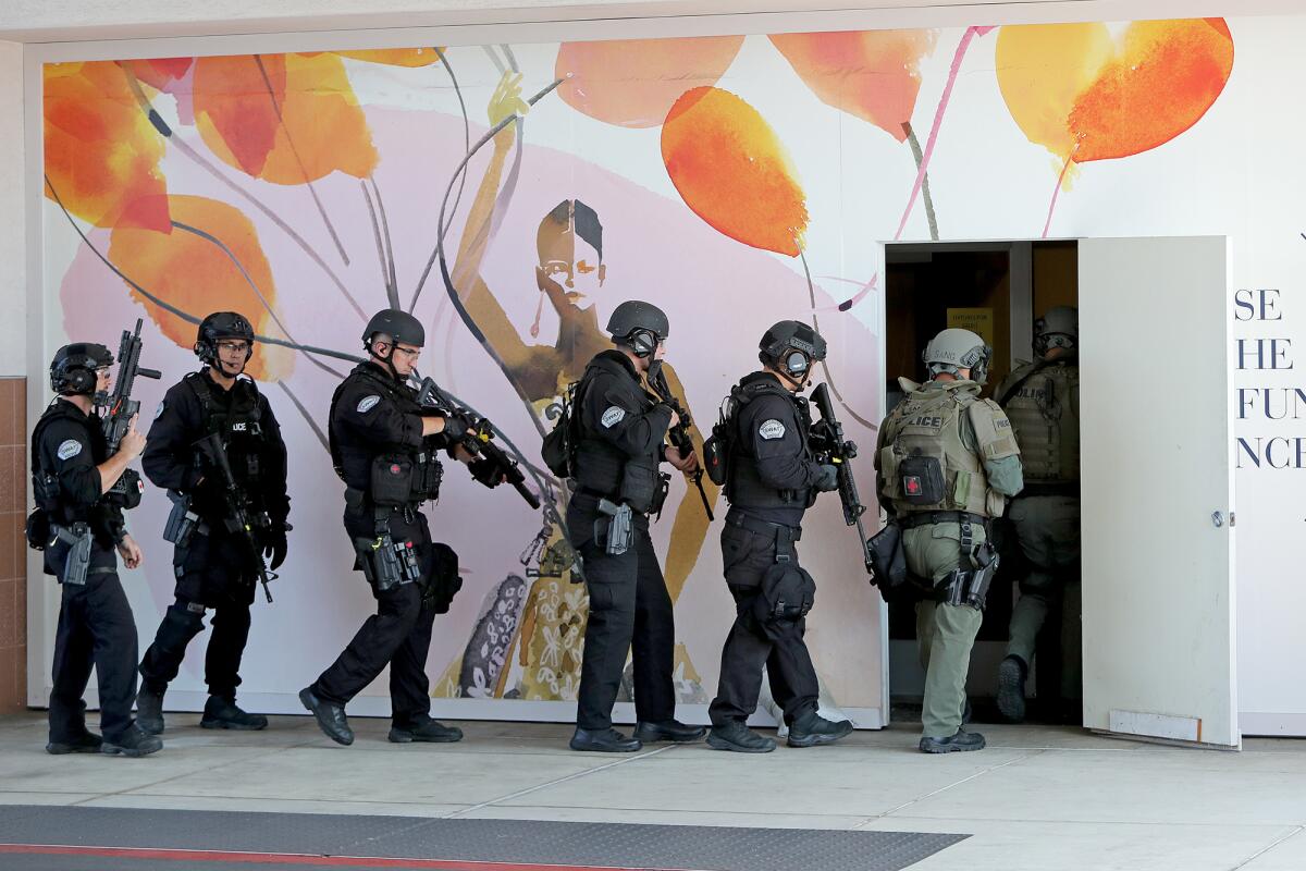 SWAT team members enter the former Sears building during a training exercise on Thursday at South Coast Plaza.