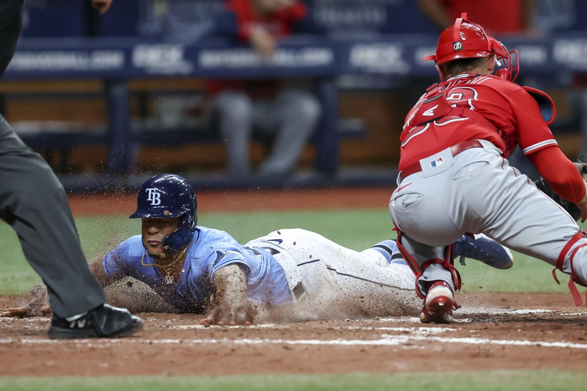 Tampa Bay Rays' Jose Siri slides in behind the tag of Angels catcher Max Stassi to score.