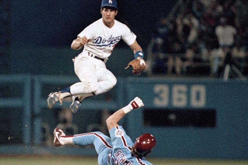 FILE - In this Oct. 6, 1984 file photo, Philadelphia Phillies' Mike Schmidt tries to take out Los Angeles Dodgers' Steve Sax at second to break up an eighth inning double-play to no avail during their second National League playoff game in Los Angeles. Steve Sax won two World Series rings, was a five-time All-Star and got nearly 2,000 hits in the big leagues. Yet to many fans, it's those half-dozen lines he uttered to a bunch of yellow cartoon characters a long time ago that really made him famous. (AP Photo/File)