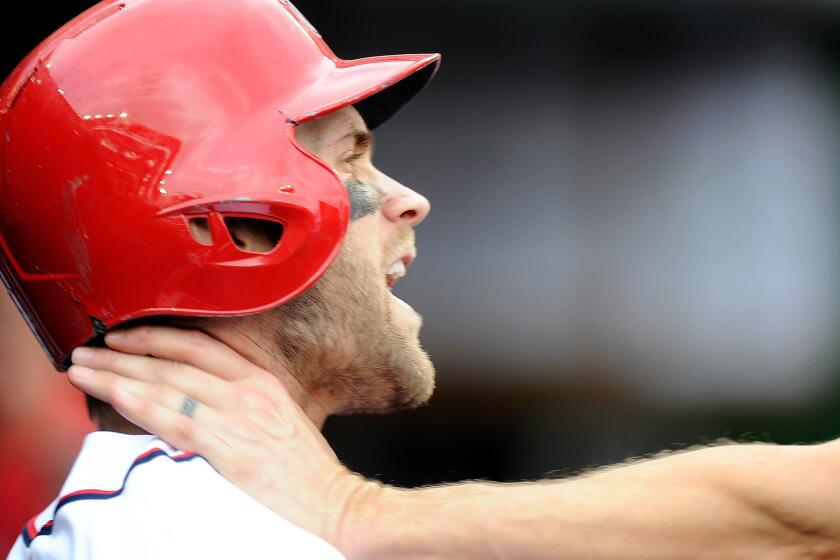 Nationals outfielder Bryce Harper is grabbed by Jonathan Papelbon in the dugout during the eighth inning of their game Sunday in Washington.