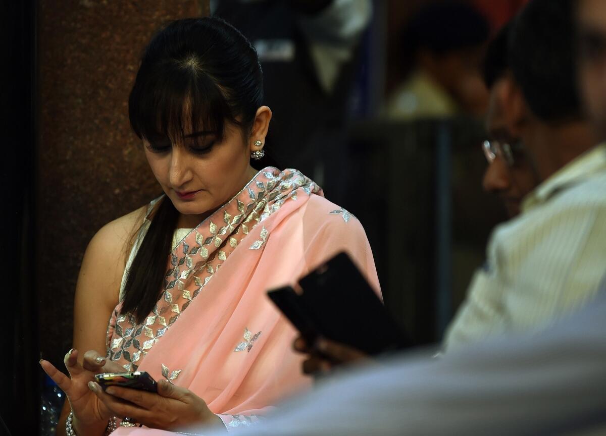 Indian commuters use their smartphones following the introduction of a free wi-fi service in Mumbai's central railway station. This year, the number of smartphone users in India is expected to exceed the size of the entire U.S. population.